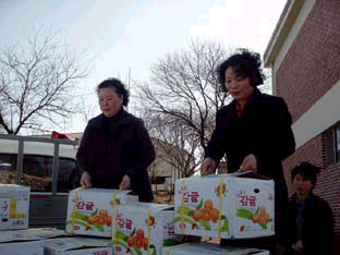 ▲ 신평면 생활개선회 회원들이 노인정에 전달할 선물을 옮기고 있다.