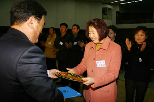 ▲ 우리마을 사랑운동 평가에서 금상을 수상한 순성면 봉소2리의 박윤자 부녀회장이 민종기 군수로부터 상패를 받고 있다.