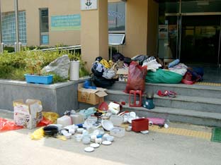 ▲ 여성단체협의회가 운영중인 중고품 알뜰매장 앞으로 온 물건. 입지 못할 의류와 쓰지못할 식기 등이 사람도 없는 일요일 오후 가정복지회관 입구에 ‘배달’됐다.
