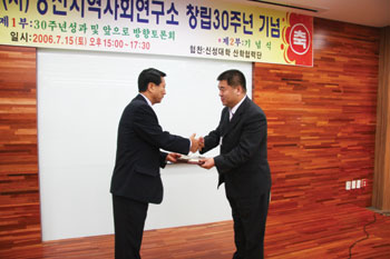 ▲ 한기흥 소장이 오상기 부군수로부터 지역사회 연구소가 지역사회 발전에 기여한 공로로 감사패를 받고 있다.