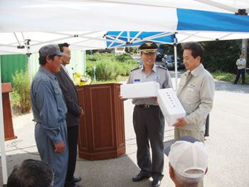 ▲ 김득곤 당진소방서장이 마을 임원들에게 소화기를 전달하고 있다.