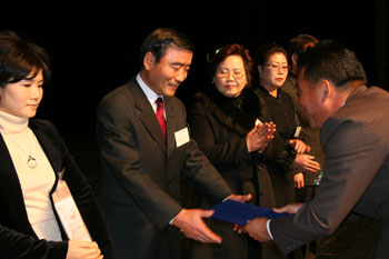 ▲ 당진자원봉사자 대축제에서 홍성재 추진위원장(오른쪽)이 감사패 수상자인 홍순성씨에게 패를 전달하고 있다.