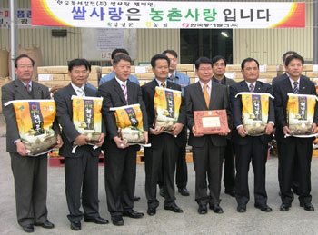 ▲ 당진화력본부 관계자들과 내빈들이 구입한 해나루쌀과 기념촬영을 하고 있다.