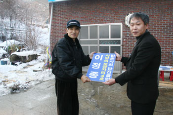 ▲ 황규기 회장(오른쪽)이 입주 약정서를 이정종씨에게 전달하고 있다.