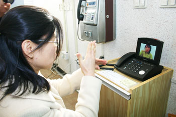 ▲ 한 자원봉사자가 영상전화기로 통화시범을 하고 있다.