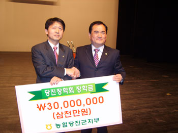 ▲ 김종화 농협 당진군지부장(왼쪽)이 민종기 군수에게 장학증서를 전달하고 기념촬영을 하고있다.