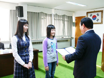 ▲ 대통령상을 수상한 강미경(오른쪽)·김민주(왼쪽) 학생이 민종기 군수로부터 상장을 전달받고 있다.