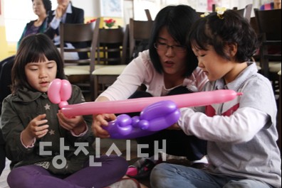 ▲ 아이들과 함께 풍선으로 토끼모자를 만들고 있는 풍선 아가페 단원