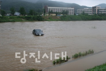 ▲ 운산면 하상 주차장에 주차된 차량이 물에 쉽쓸려 역천 한가운데 잠겨 있다.