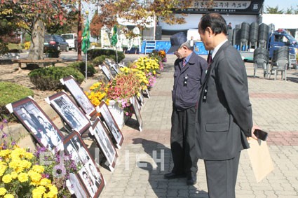 ▲ 박정희 전 대통령 추모제에 참석한 한 군민이 사진 전시를 구경하고 있다.