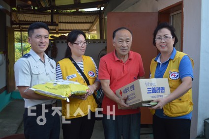 ▲ 당진지구협의회 황선숙(사진 우측) 회장과 당진3동봉사회 심순옥 회장, 당진경찰서 생활안전과 이진수 과장이 독거노인에게 쌀과 라면 등의 위문품을 전달하고 있다.
