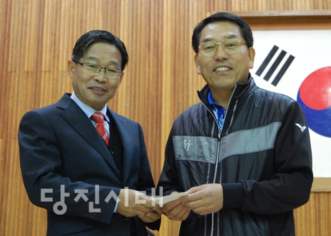 ▲ 오장교 회장(오은쪽)이 상희구 교장에게 발전기금을 전달하고 있다.