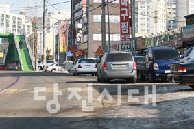 ▲ 신평면 서정초등학교와 거산삼거리 사이의 구간은 보도가 끊겨있고, 주차차량으로 인해 학생들이 차도로 지나야 하는 등 사고 우려가 있다. 시는 보도설치를 추진 중이나 보상협의가 지연돼 공사를 시작하지 못하고 있다.
