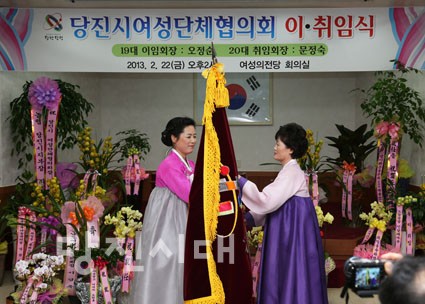 ▲ 오정순 이임회장이 문정숙 취임회장에게 회기를 전달하고 있다.