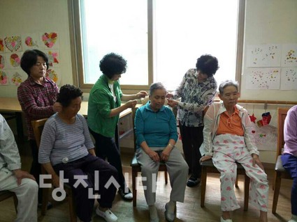 ▲ 귀에 신박석을 붙이고 있는 귀사랑 봉사단원들