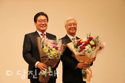 ▲ 당진시복지재단 이·취임식이 지난 8일 열린 가운데 이임한 김홍장 시장이 방두석 취임 이사장에게 복지재단 깃발을 전달하고 있다.