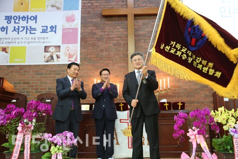 ▲ 지난 11일 초락감리교회에서 기독교대한감리회 남선교회 충청연회연합회 이취임 감사예배 및 이취임식이 열렸다. 이 가운데 백성옥 취임회장이 연합회기를 전달받는 모습