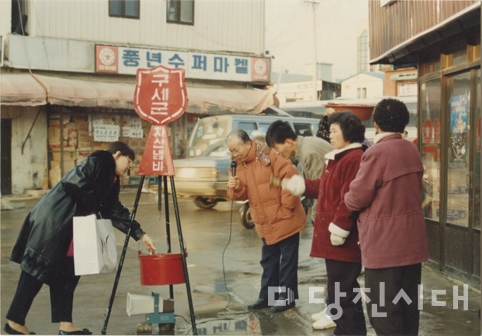 ▲ 풍년수퍼마켓 앞 구세군 자선냄비에 한 시민이 기부하고 있다.