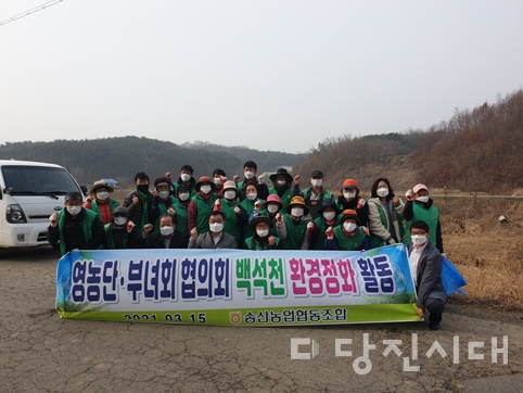 ▲ 지난 15일 송산농협 영농단‧부녀회가 백석천에서 환경정화활동을 실시했다.