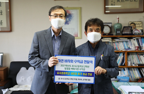 ▲ 이규용 호서고 교장(좌)이 안명수 전 당진시장애인후원회장(오)에게 밤절골 벼룩시장을 통해 얻은 수익금을 전달했다.