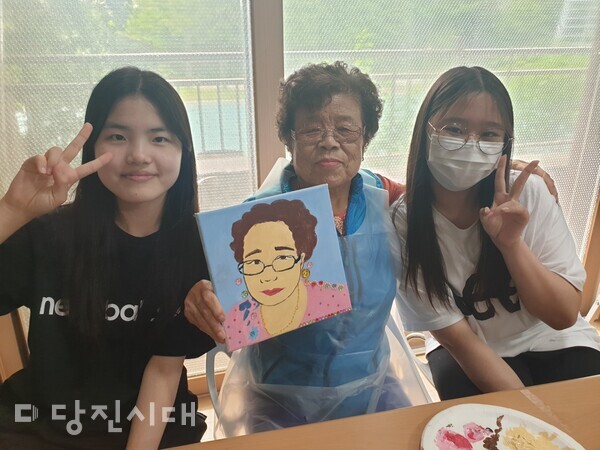 어르신이 자화상을 완성하고 송산중학교 학생들과 기념사진을 촬영했다.