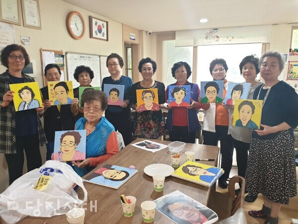 활동에 참여한 어르신들이 자신의 자화상 그림을 들고 기념사진을 찍었다.
