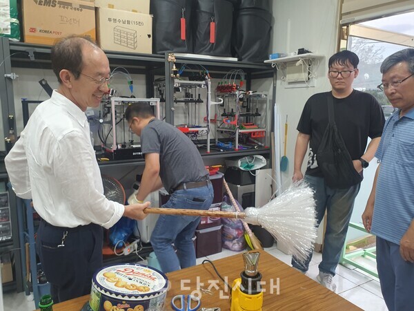페트병으로 빗자루를 만들고 있다.