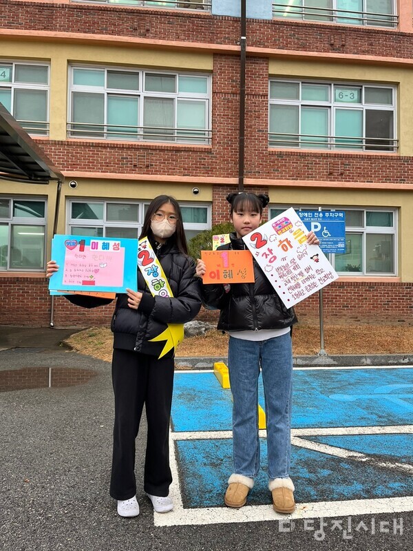 당진초등학교 전교학생회장 선거 출마한 이혜성(왼) · 장하음(오) 학생이 서로 어깨띠와 홍보피켓을 바꿔들고 선거운동을 함께 했다. 