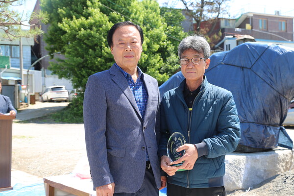 김복선 기념바위 제막식이 지난 8일 신평면 서해중앙신협 앞에서 열린 가운데, 기념바위를 만든 노함래 함래석예원 대표(오른쪽)가 기념바위 건립 추진위원회로부터 감사패를 받았다.