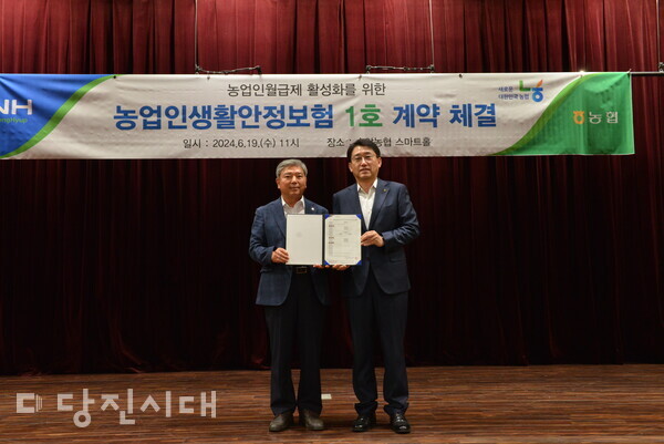 송악농협 홍진희 조합장(왼쪽)과 NH농협손해보험 서국동 대표이사(오른쪽)가 계약증권 교부 후 기념사진을 촬영했다.