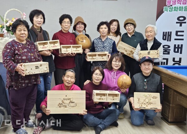 마을주민들이 직접 만든 우드버니 생활용품을 들고 기념사진을 촬영했다.'
