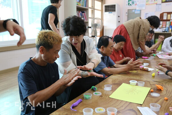 김선순 당진3동 분회장(왼쪽에서 두번째)이 한빛공동체 이용자의 클레이 활동을 돕고 있다.