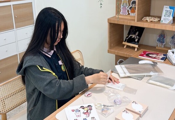 최례유 학생이 직접 디자인한 굿즈 제품을 포장하고 있다.