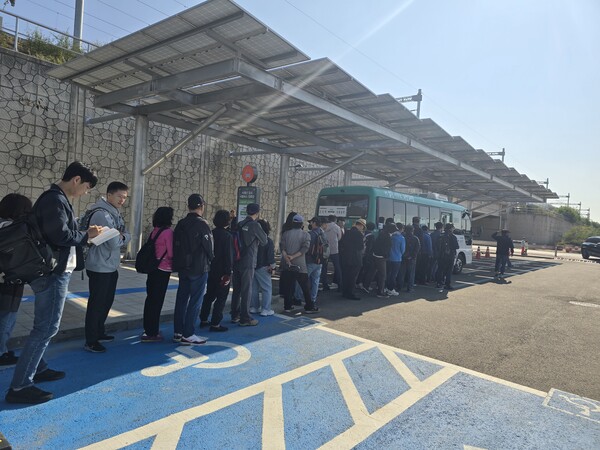 사람들이 초지역으로 향하는 셔틀버스를 탑승하고 있다.