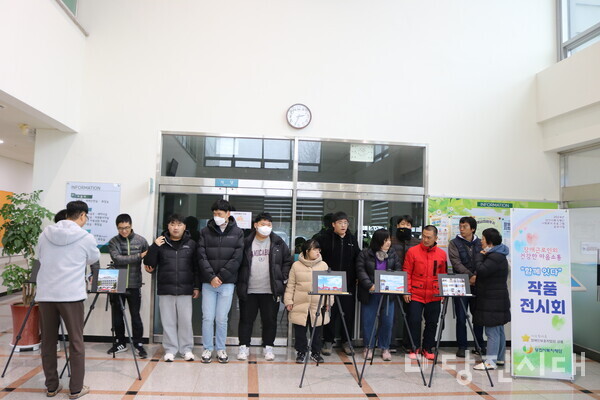 지난 25일부터 오는 29일까지 송산사회복지관에서 전시 중인 장애인근로인의 건강한 마음소통 ‘함께 잇다’의 전시관에서 장애근로인들이 모여 기념촬영을 진행했다.