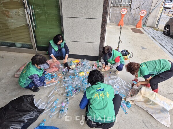 부녀회원들과 함께 플라스틱병을 깨끗하게 만들고 있는 김태숙 씨