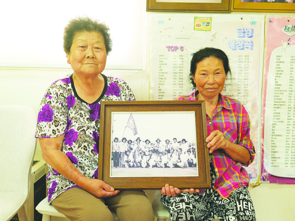 당시 농악대로 활동했던 사진 왼쪽부터 백순자 어르신과 황귀자 어르신이 당시 활동했던 사진을 들고 있다.
