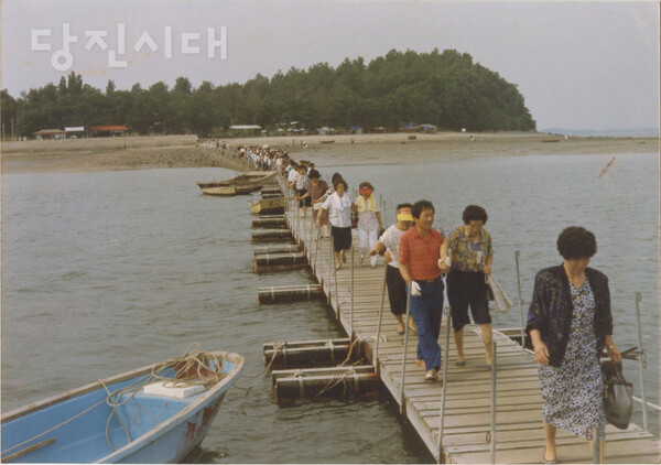 1990년대, 행담도를 찾은 관광객들이 선착장을 통해 줄지어 배를 타러 가고 있다. [사진제공 : 표선동_행담도 원주민]