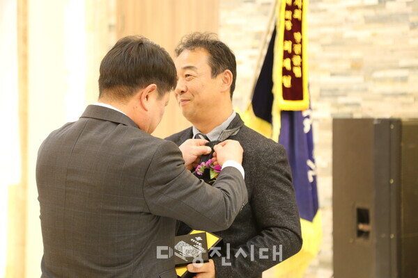 최재원 회장에게 배지를 달아주는 모습