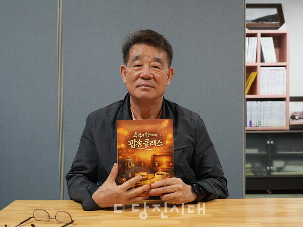 직접 만든 교재 '추억과 함께하는 팝송클래스'를 들고 있는 이영두 영어 교사
