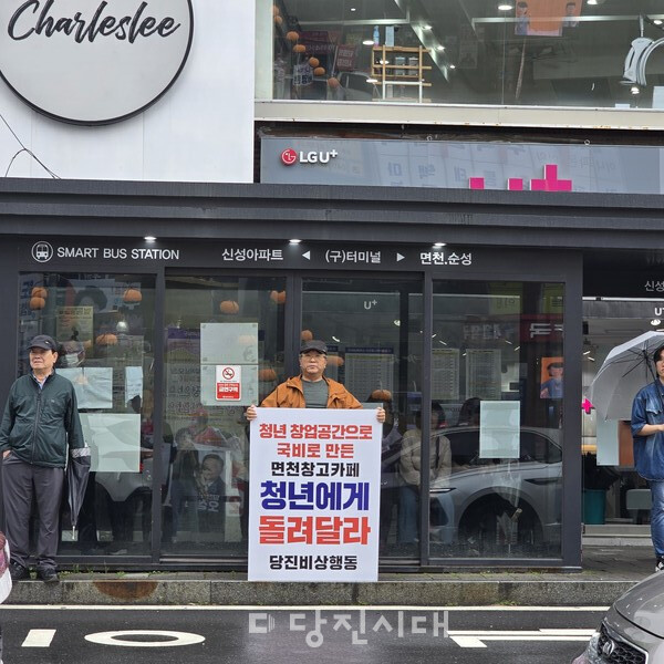 당진비상행동이 당진 구터미널 버스정류장에서 ‘면천창고카페 청년에게 돌려달라며’ 1인 시위를 펼치고 있다.