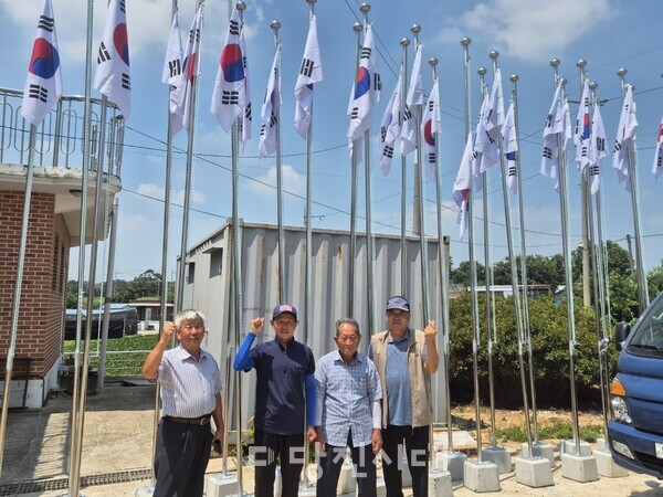 직접 제작한 25개의 국기 게양대 앞에 선 한상철 회장과 염광옥, 최대식, 임한정 씨(왼쪽부터)